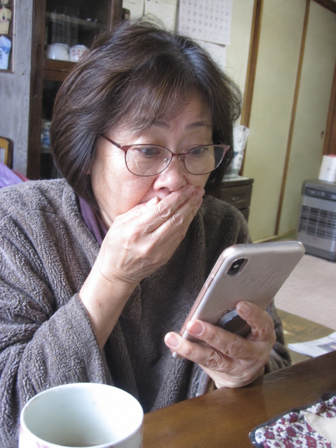 スマートフォンを見る60代女性